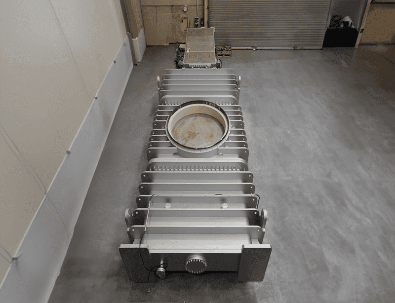100-inch industrial gate valve with cylindrical body and horizontal bars, positioned on factory floor.