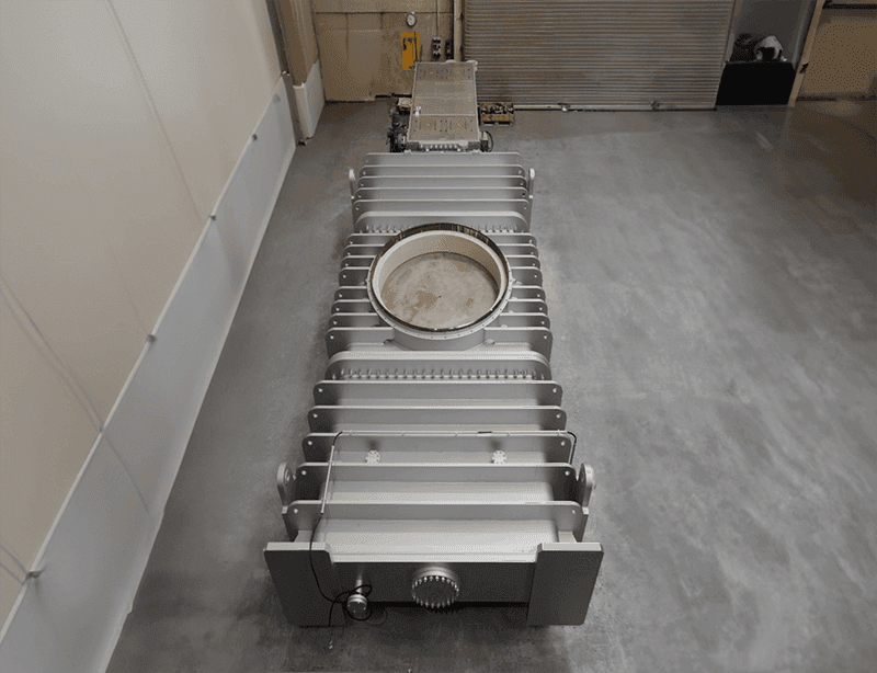 100-inch industrial gate valve with cylindrical body and horizontal bars, positioned on factory floor.