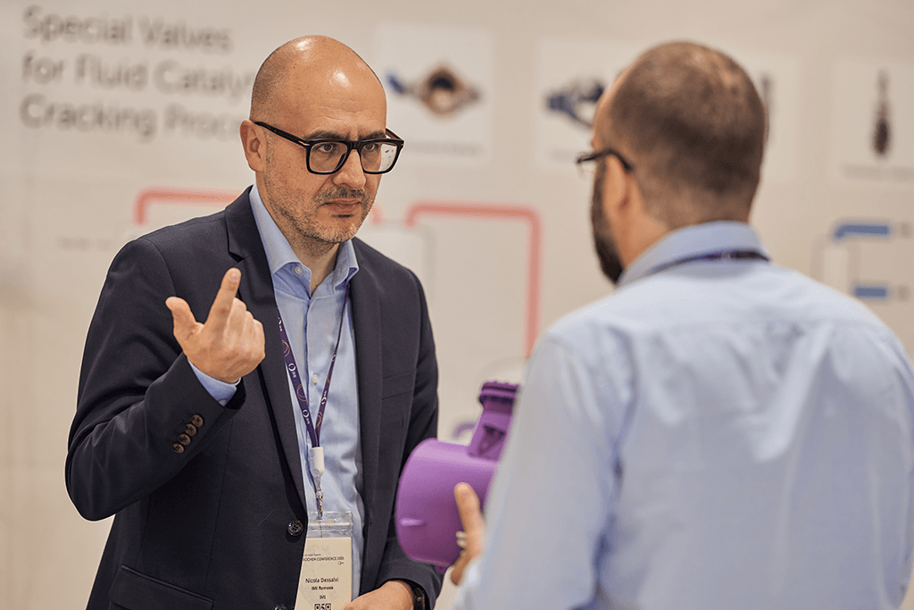 Nicola Dessalvi discusses a valve component with an attendee at the 2025 conference