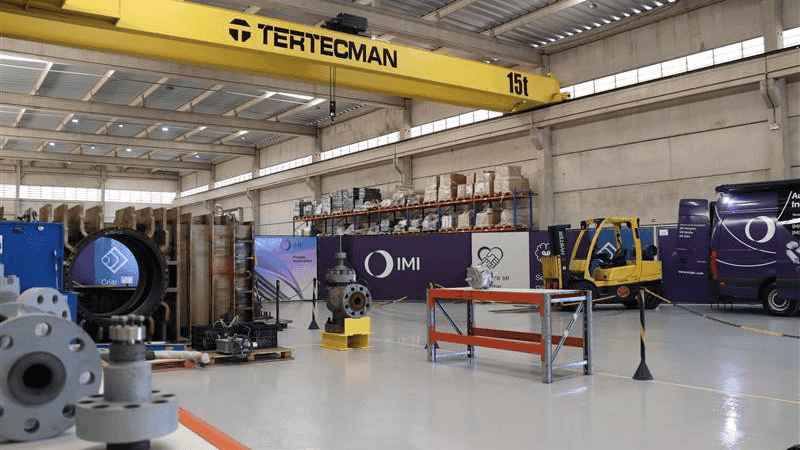 IMI Brazil facility interior showing workshop space, valve equipment, and branded service vehicles.